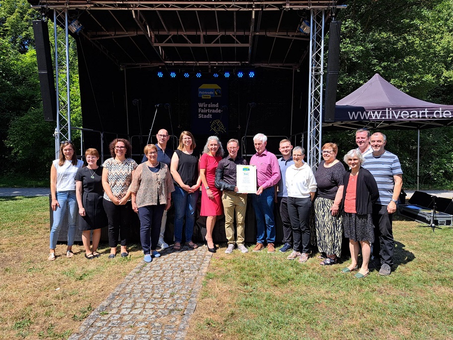 Manfred Holz, Ehrenbotschafter der Kampagne "Fairtrade Towns", überreicht dem Mosbacher Oberbürgermeister Julian Stipp, Mitarbeiter*innen der Stadtverwaltung und Kampagnen-Unterstützern die Urkunde zur "Fairtrade Town"-Mosbach. ©Stadt Mosbach&nbsp;